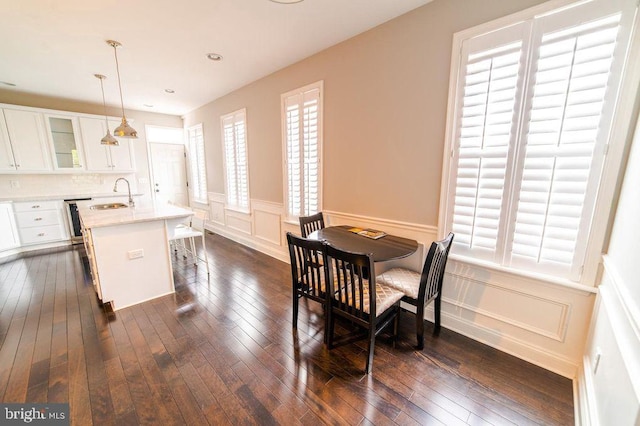 dining space with recessed lighting, a wainscoted wall, dark wood-style floors, and a decorative wall