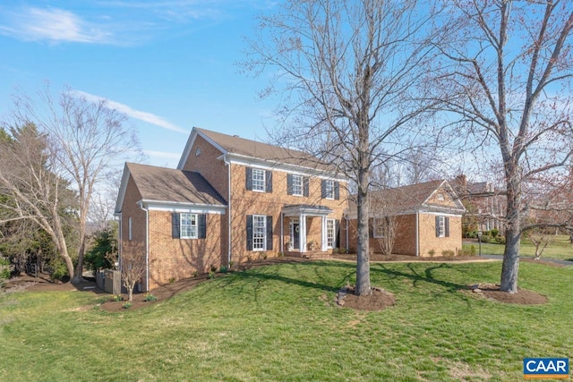 colonial house with brick siding and a front yard