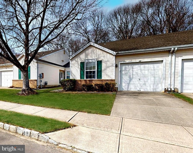 view of front facade with a garage, brick siding, concrete driveway, and a front yard