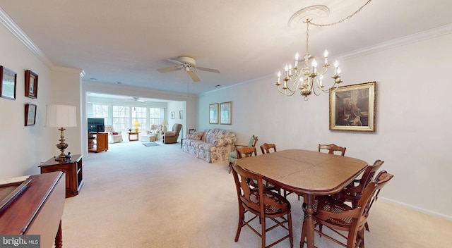 dining space with crown molding, ceiling fan with notable chandelier, baseboards, and light carpet