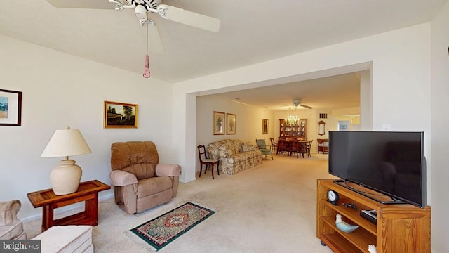 carpeted living area with a ceiling fan