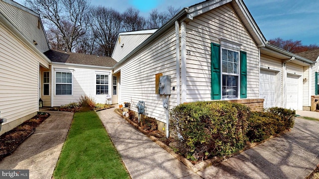 view of side of home featuring driveway and an attached garage