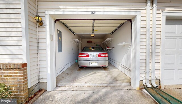 garage featuring electric panel and driveway