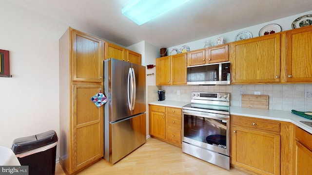 kitchen featuring tasteful backsplash, appliances with stainless steel finishes, and light countertops