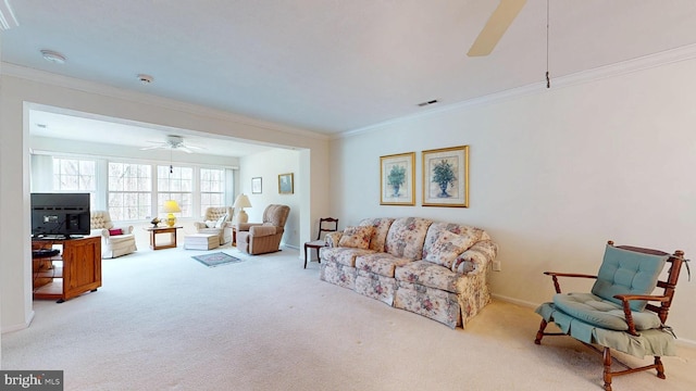 living area with visible vents, crown molding, baseboards, carpet, and a ceiling fan