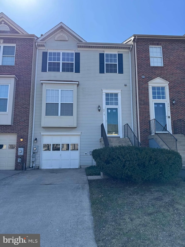 view of property with a garage and driveway