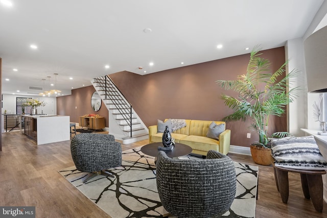 living room with recessed lighting, stairs, and wood finished floors