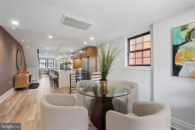 dining space featuring light wood-type flooring, visible vents, baseboards, and recessed lighting