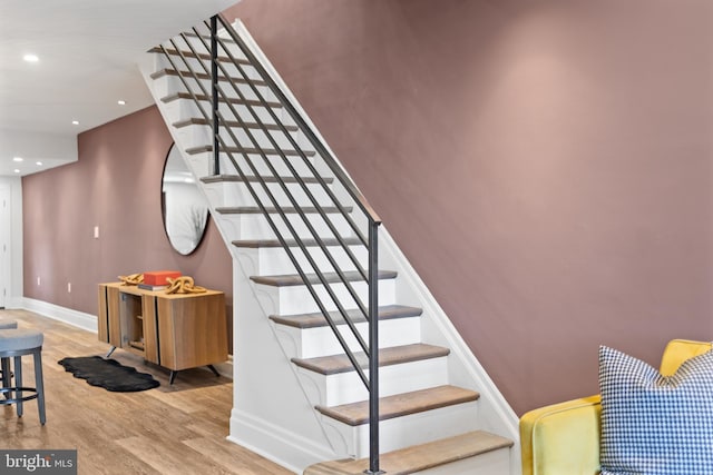 staircase with recessed lighting, baseboards, and wood finished floors