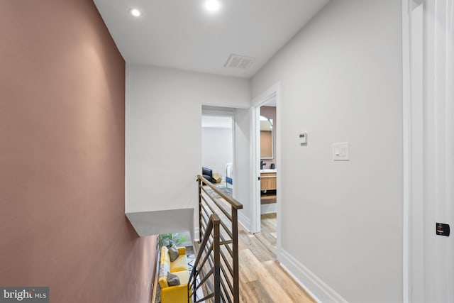 corridor featuring visible vents, an upstairs landing, recessed lighting, light wood finished floors, and baseboards