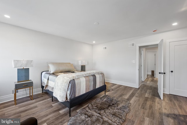 bedroom with visible vents, baseboards, and wood finished floors