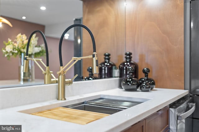 interior details with recessed lighting, light countertops, freestanding refrigerator, and a sink