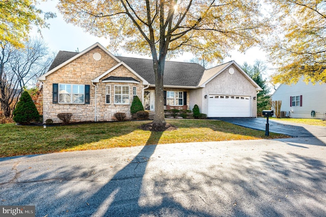 view of front facade with aphalt driveway, a garage, a front lawn, and a shingled roof