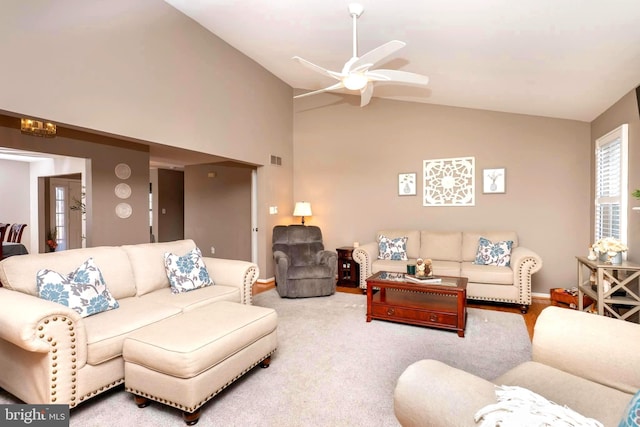 living room featuring visible vents, baseboards, carpet floors, vaulted ceiling, and a ceiling fan