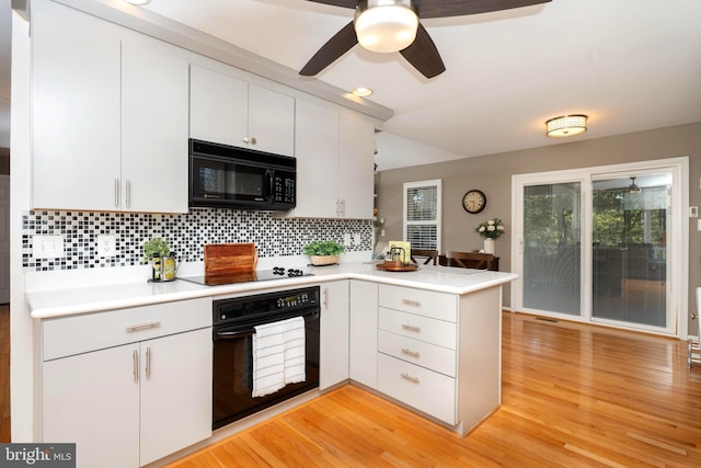 kitchen featuring light wood finished floors, a peninsula, decorative backsplash, black appliances, and light countertops