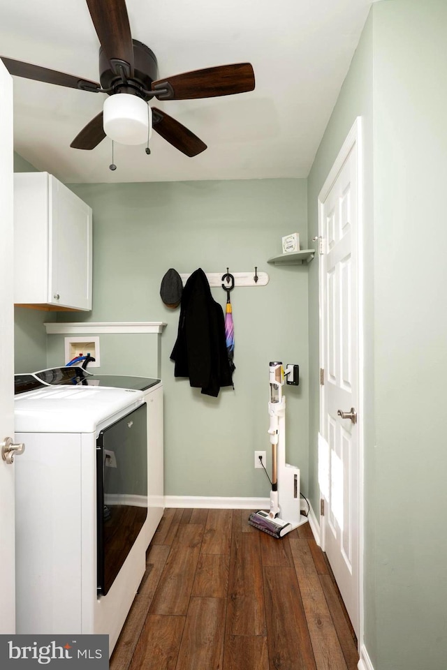 clothes washing area with dark wood finished floors, separate washer and dryer, cabinet space, and baseboards