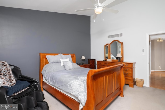 bedroom featuring visible vents, light colored carpet, baseboards, and a ceiling fan