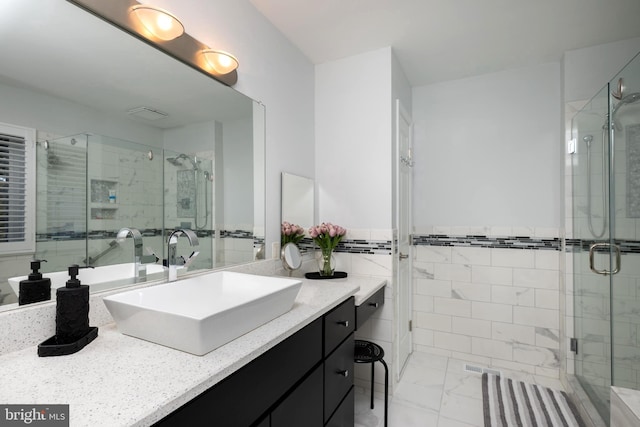 bathroom with vanity, a shower stall, marble finish floor, and wainscoting