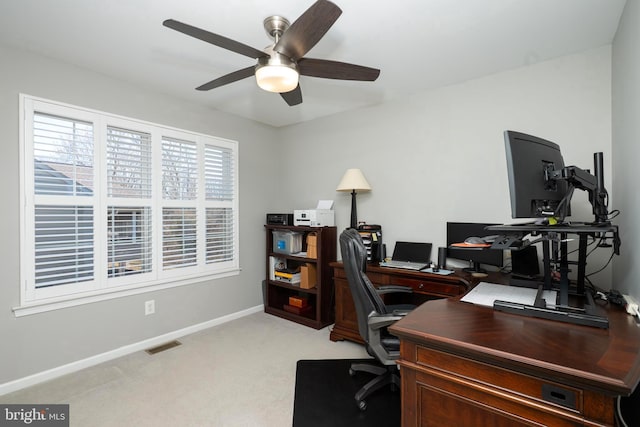 home office with visible vents, light carpet, baseboards, and ceiling fan