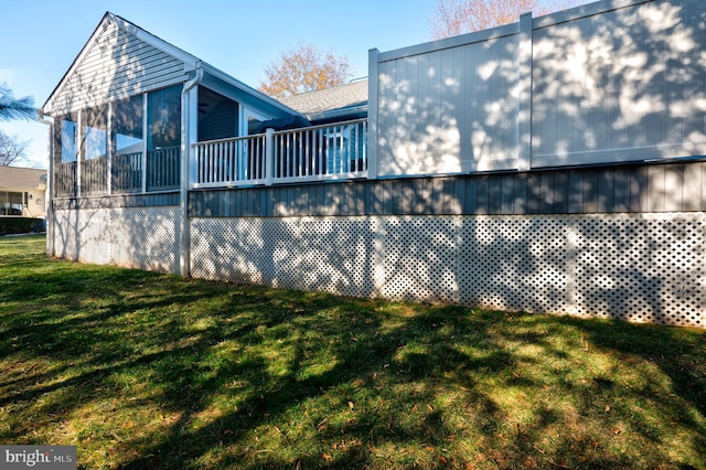 view of property exterior with a lawn and a sunroom