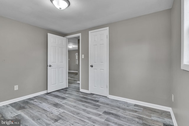 unfurnished bedroom with wood finished floors and baseboards