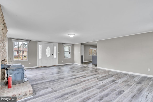 foyer entrance with light wood finished floors, plenty of natural light, and baseboards