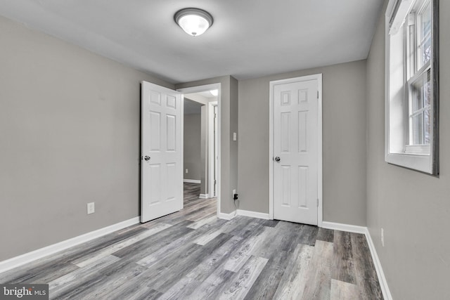 unfurnished bedroom featuring baseboards and wood finished floors