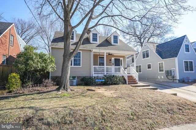 view of front of property featuring a porch, ceiling fan, a front lawn, and a shingled roof