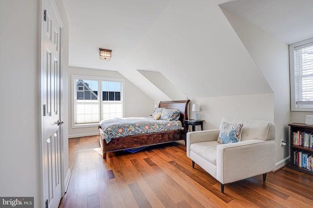 bedroom with vaulted ceiling and hardwood / wood-style flooring