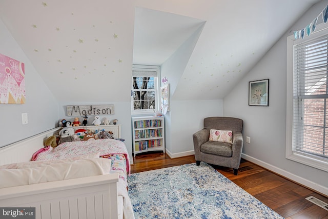 bedroom with vaulted ceiling, visible vents, baseboards, and wood finished floors