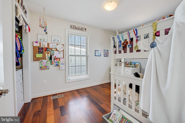 bedroom featuring visible vents, baseboards, and wood finished floors