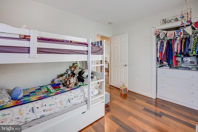 bedroom featuring a closet, baseboards, and wood finished floors