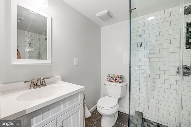 full bathroom with toilet, a shower stall, tile patterned flooring, baseboards, and vanity