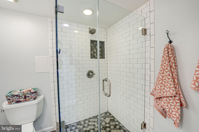 bathroom featuring toilet and a stall shower