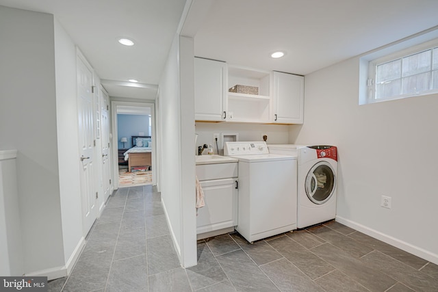 washroom with baseboards, recessed lighting, cabinet space, a sink, and washing machine and dryer