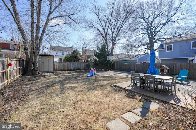 view of yard with an outbuilding, a fenced backyard, and a storage shed