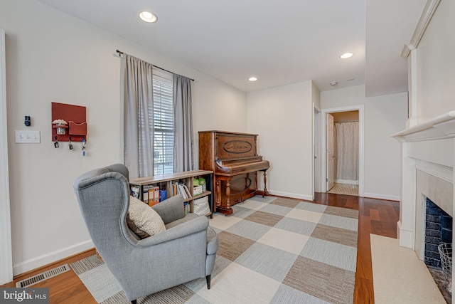 sitting room with visible vents, recessed lighting, a fireplace, and wood finished floors