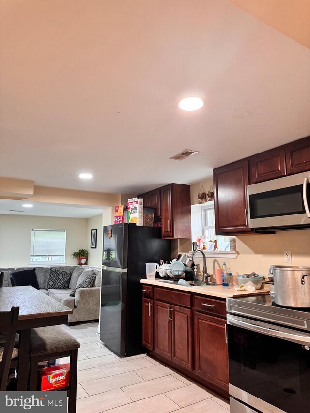 5604 Newton St, Hyattsville, MD 20784 - kitchen with appliances with stainless steel finishes, light countertops, a sink, open floor plan, and recessed lighting