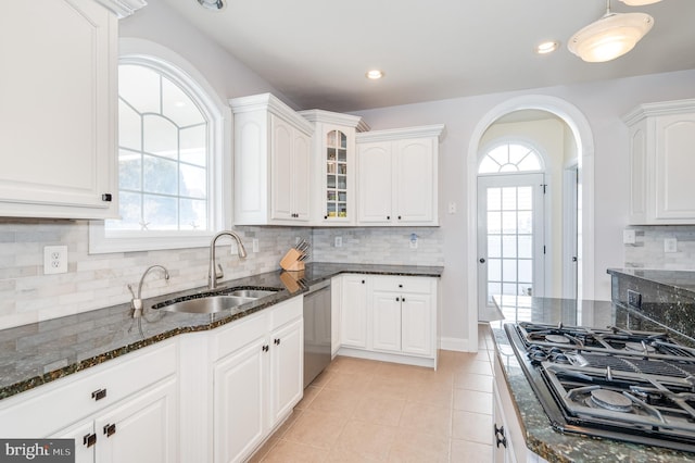 kitchen with a sink, black gas cooktop, dark stone countertops, glass insert cabinets, and dishwasher