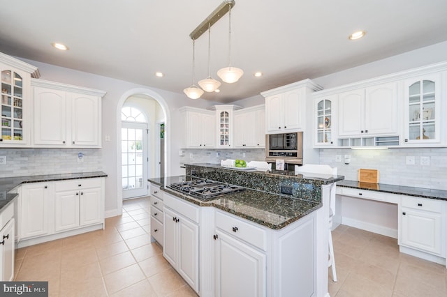 kitchen featuring arched walkways, black appliances, and white cabinets