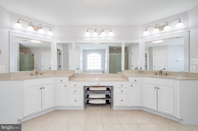 full bathroom featuring tile patterned floors, two vanities, a stall shower, and a sink