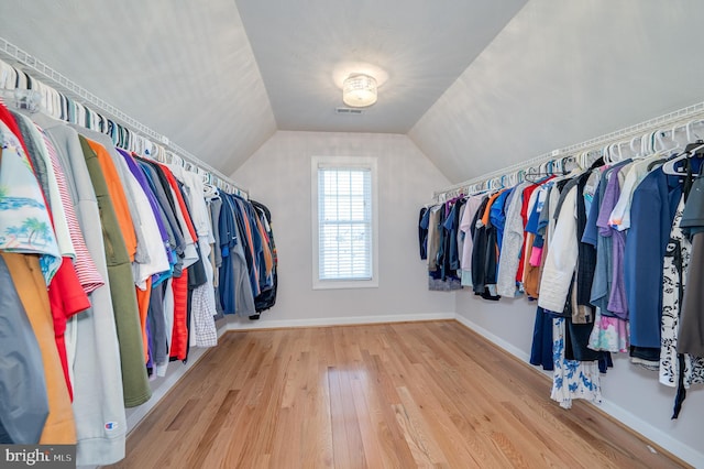 spacious closet featuring vaulted ceiling and wood finished floors