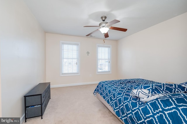 bedroom featuring baseboards, light carpet, and a ceiling fan