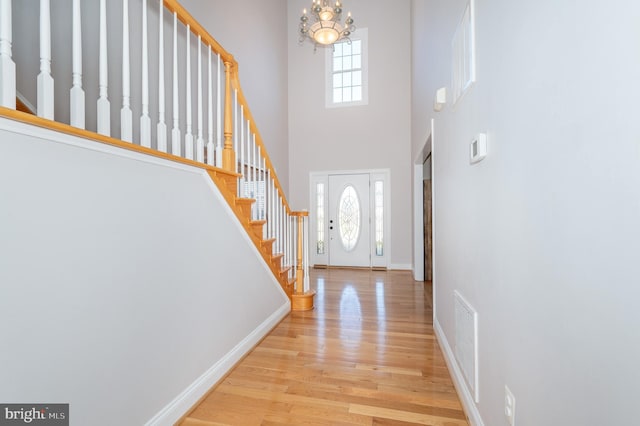 entrance foyer featuring a notable chandelier, stairway, and a wealth of natural light