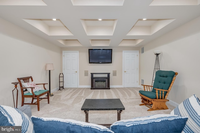 living area with baseboards, light colored carpet, and a glass covered fireplace