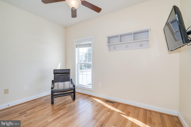 sitting room with visible vents, baseboards, and wood finished floors