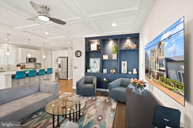 living area with coffered ceiling, recessed lighting, ceiling fan, beamed ceiling, and light wood-type flooring