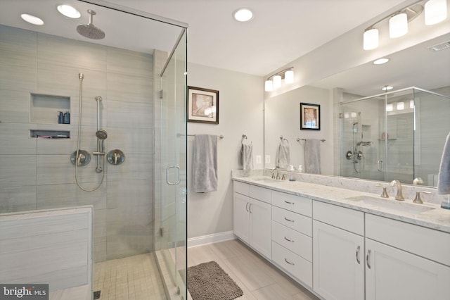 full bathroom featuring a sink, visible vents, a stall shower, and double vanity