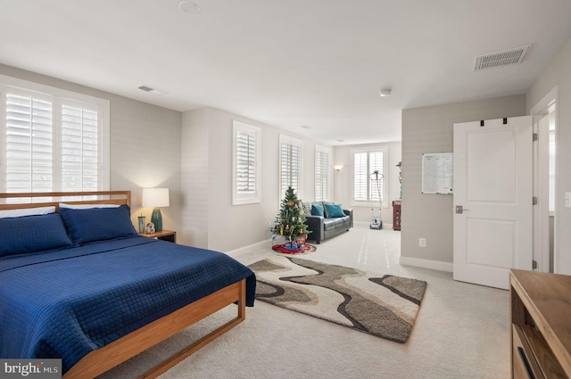 carpeted bedroom featuring baseboards and visible vents