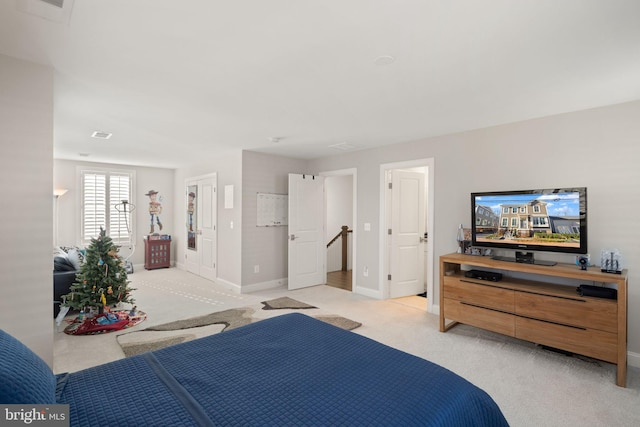 bedroom with visible vents, baseboards, and light carpet